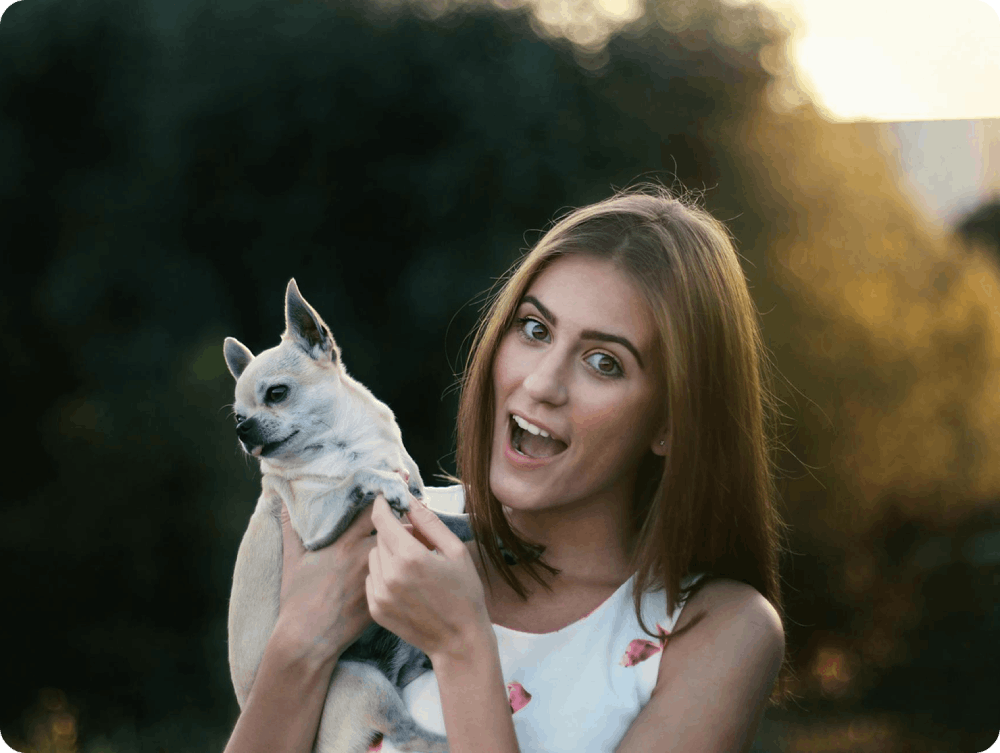 A woman holding a dog in her arms.